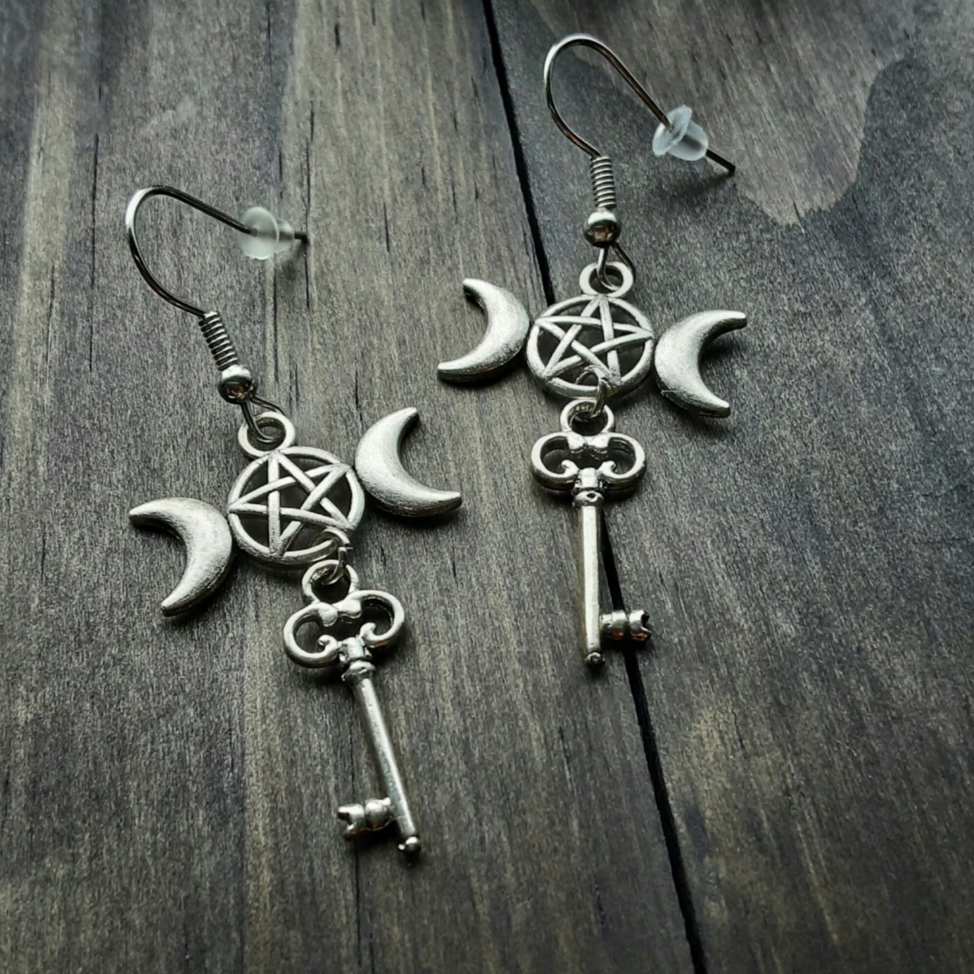 Hekate key earrings Triple Moon Goddess symbol charms on hooks on wooden background